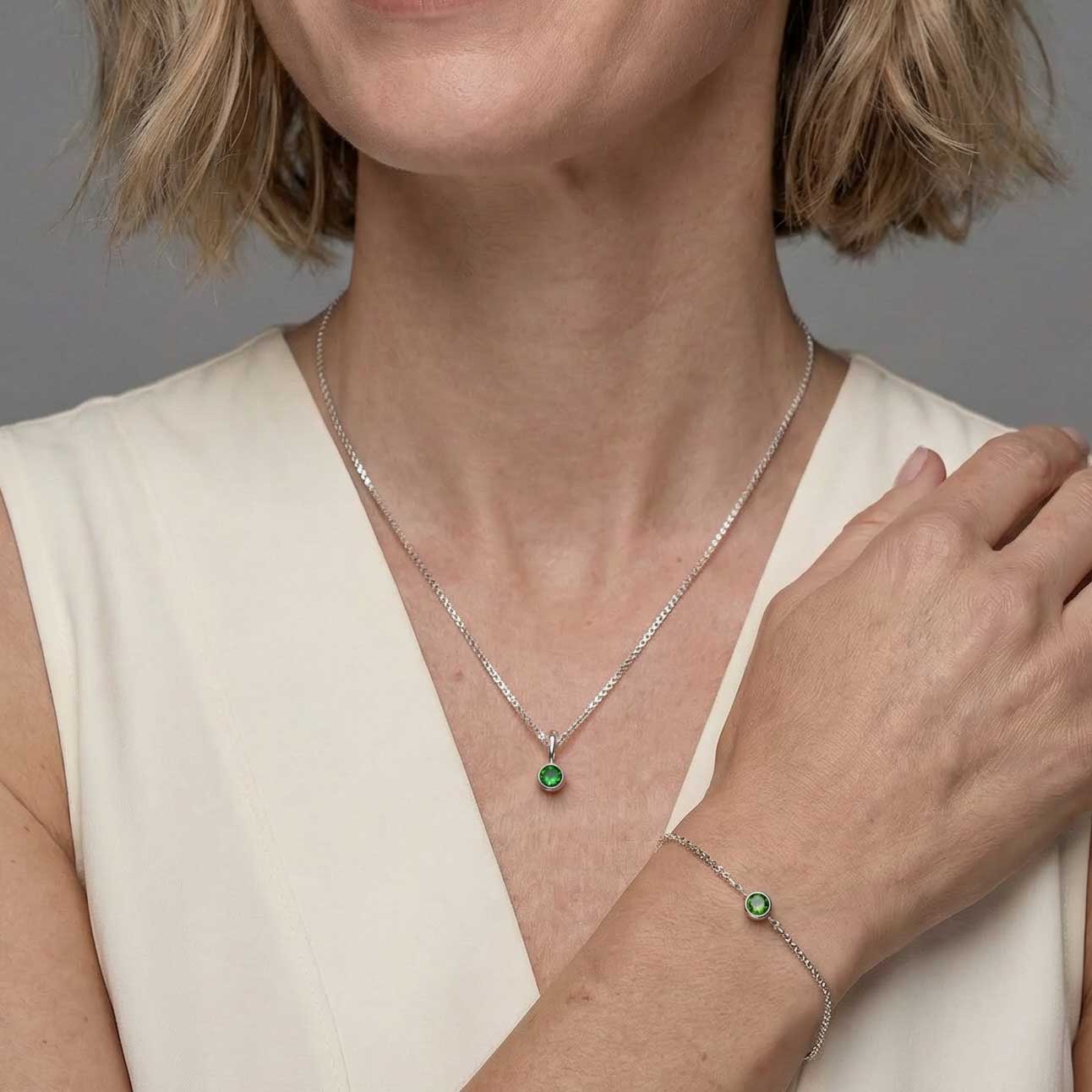 Delicate sterling silver bracelet and necklace set featuring a Siberian Emerald gemstone, highlighting modern, sculptural design with a sliding adjuster for a refined look.