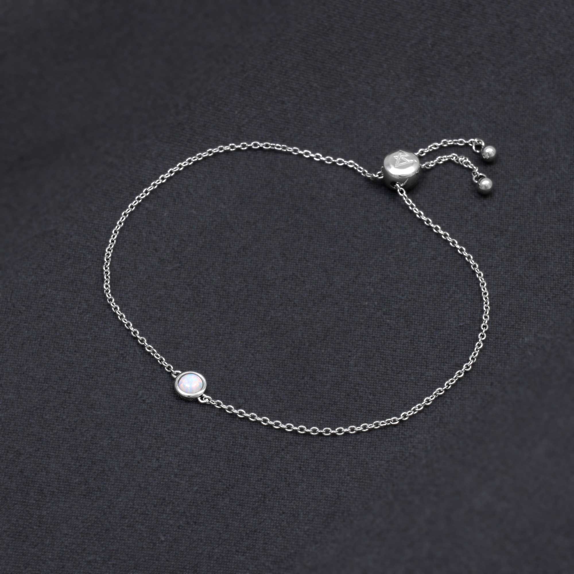 Delicate sterling silver bracelet featuring a smooth opal set on a fine adjustable chain, showcasing expert British craftsmanship with a minimalist, contemporary design.