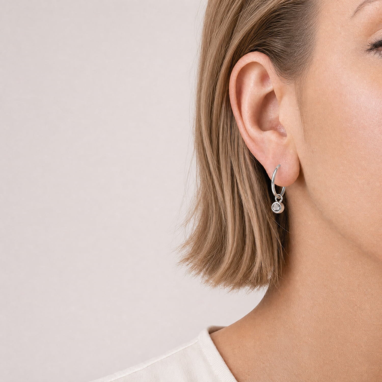 Delicate sterling silver hoop earrings featuring polished aqua chalcedony stones, showcasing expert British craftsmanship in a contemporary sculptural design.
