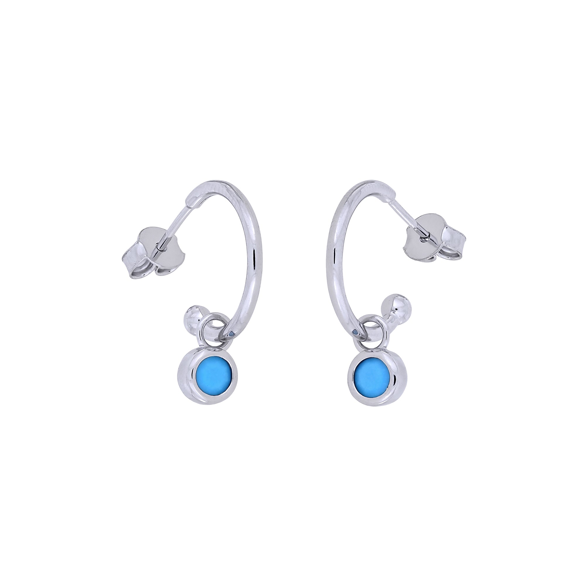 Delicate sterling silver hoop earrings featuring small round turquoise birthstones, exemplifying refined craftsmanship and contemporary British jewellery design.
