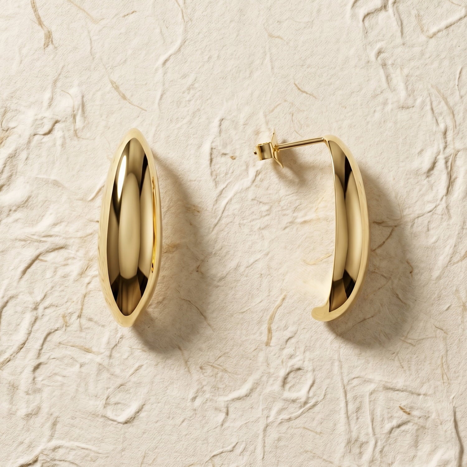 Pair of large gold vermeil earrings with a smooth, elongated curved design and secure post backs, showcasing modern elegance in a polished finish.
