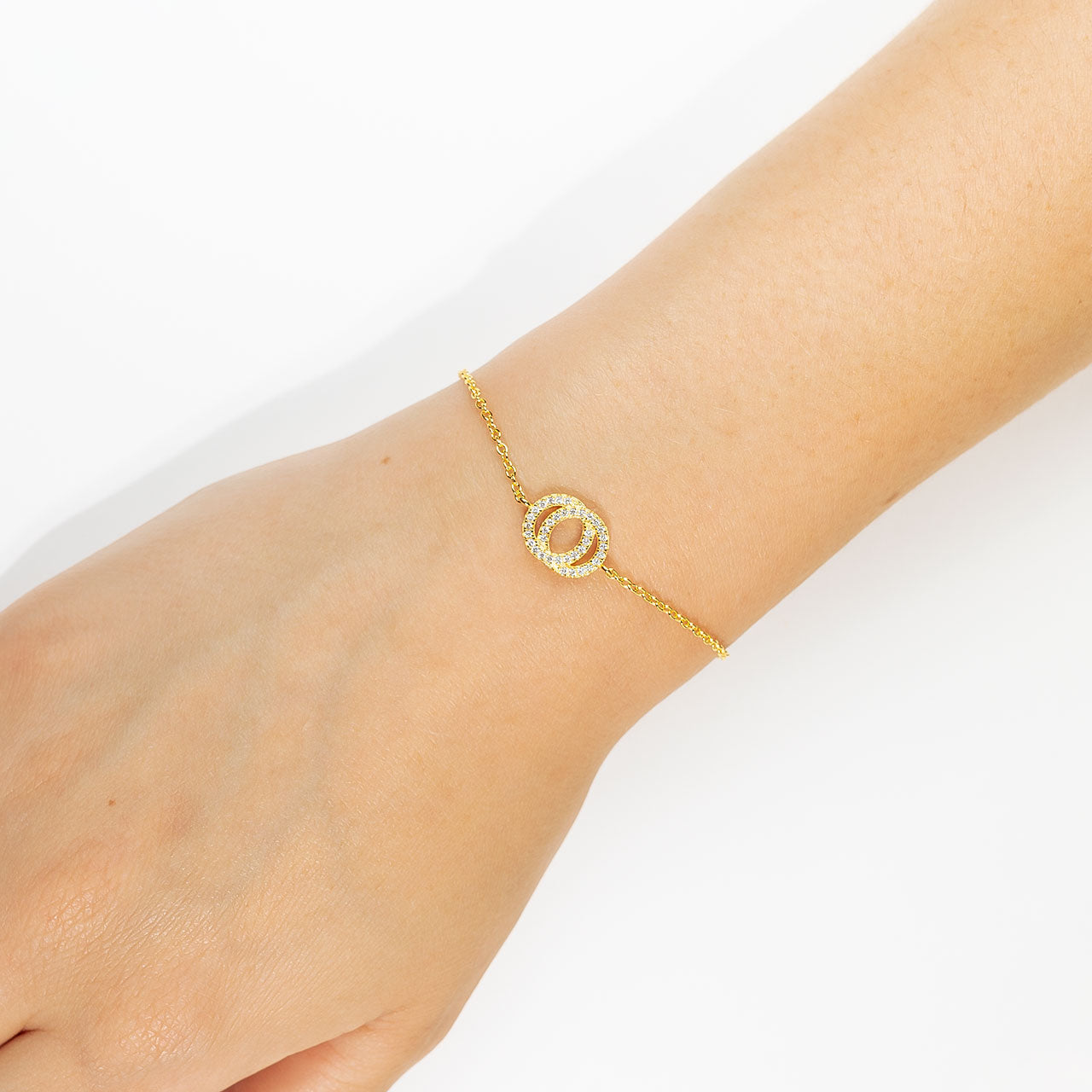 Delicate gold vermeil bracelet featuring two interlocking circles embellished with sparkling cubic zirconia, adjustable for a refined and elegant look.