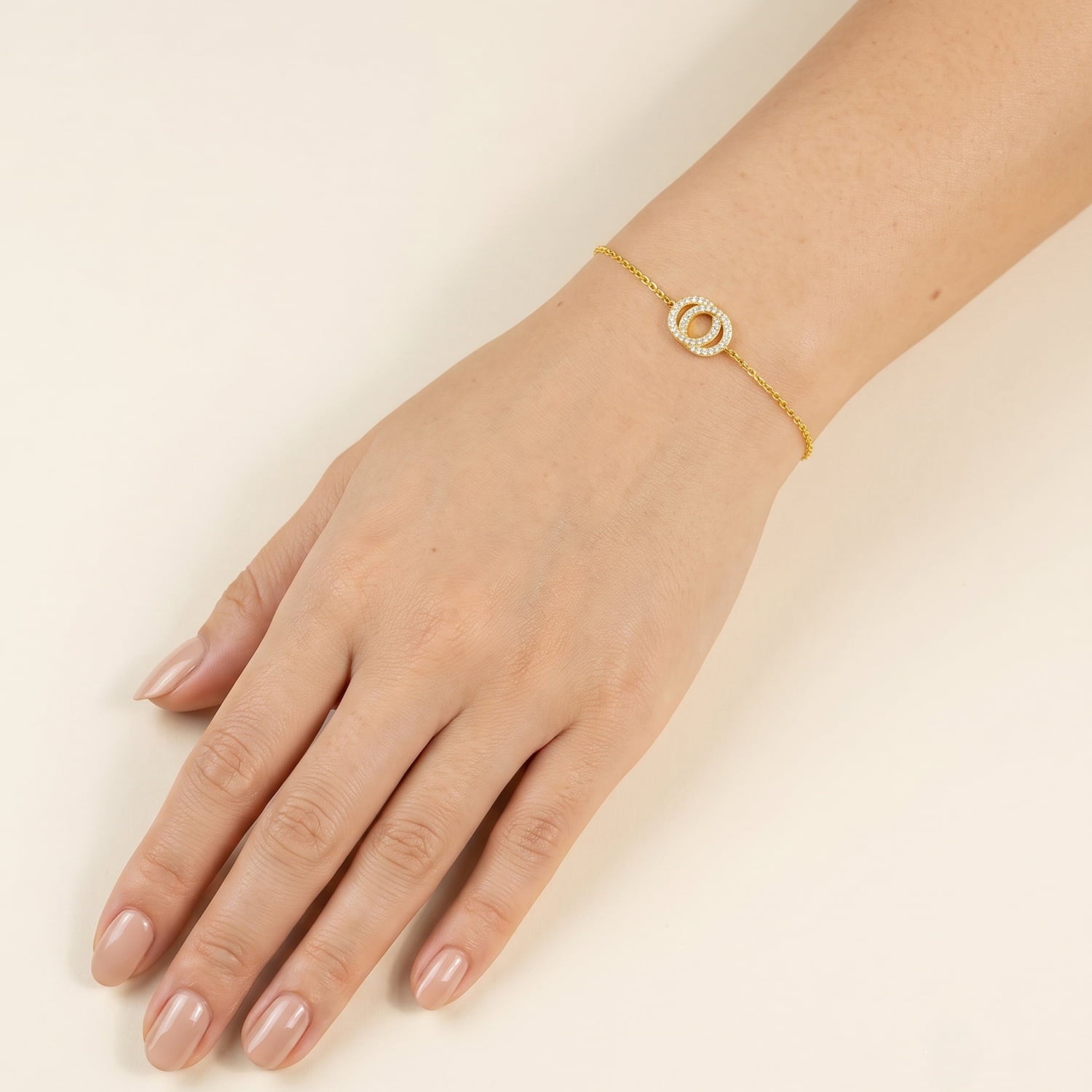 Delicate gold vermeil bracelet featuring two interlocking circles embellished with sparkling cubic zirconia, adjustable for a refined and elegant look.