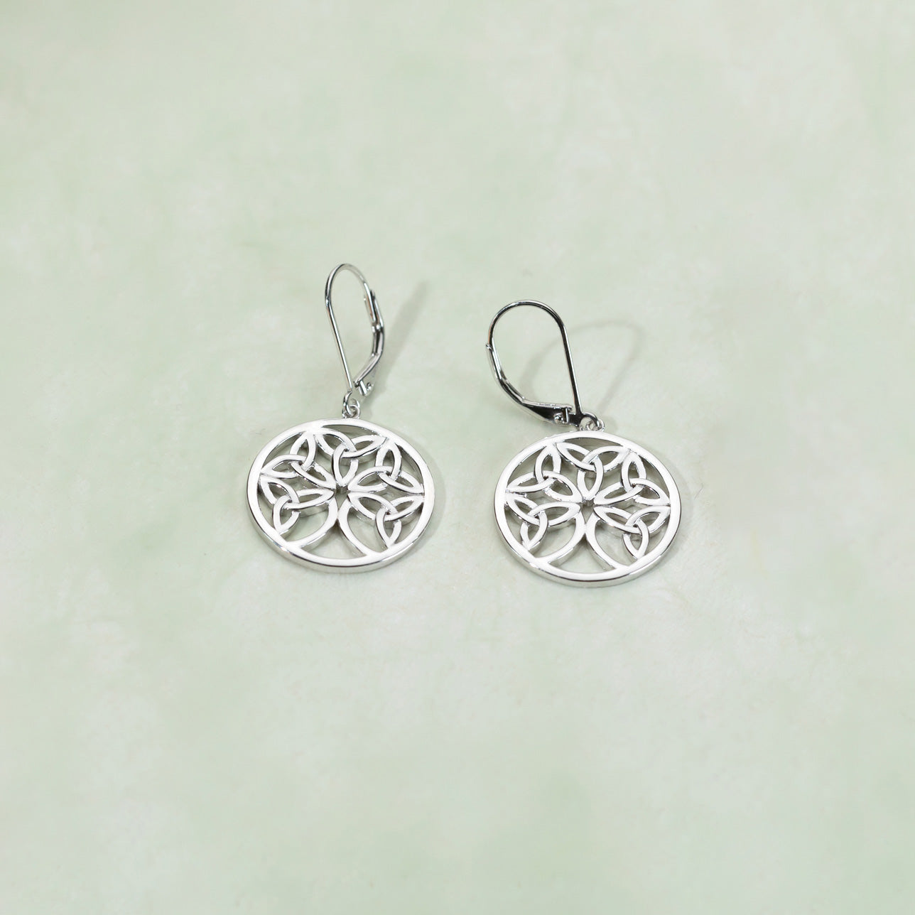 Pair of sterling silver drop earrings featuring an intricately crafted Celtic Tree of Life design within circular frames, showcasing a sculptural and elegant style.