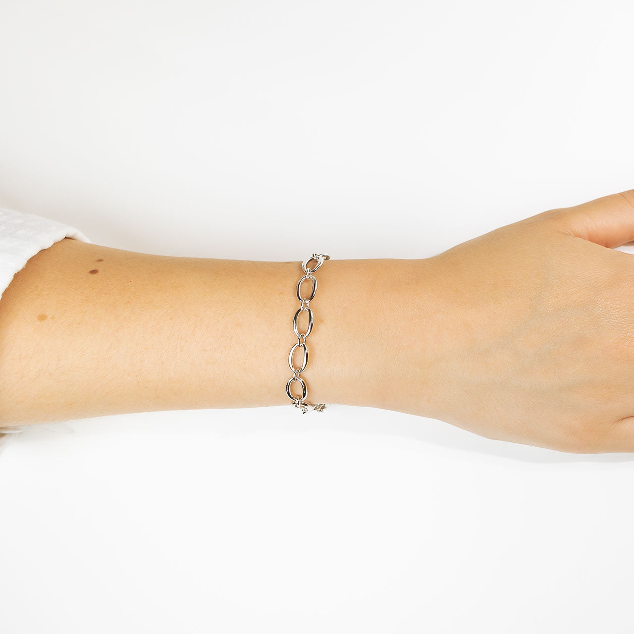 Sterling silver bracelet featuring linked open oval shapes with a polished finish, elegantly draped on the wrist for a contemporary and refined silver jewellery look.