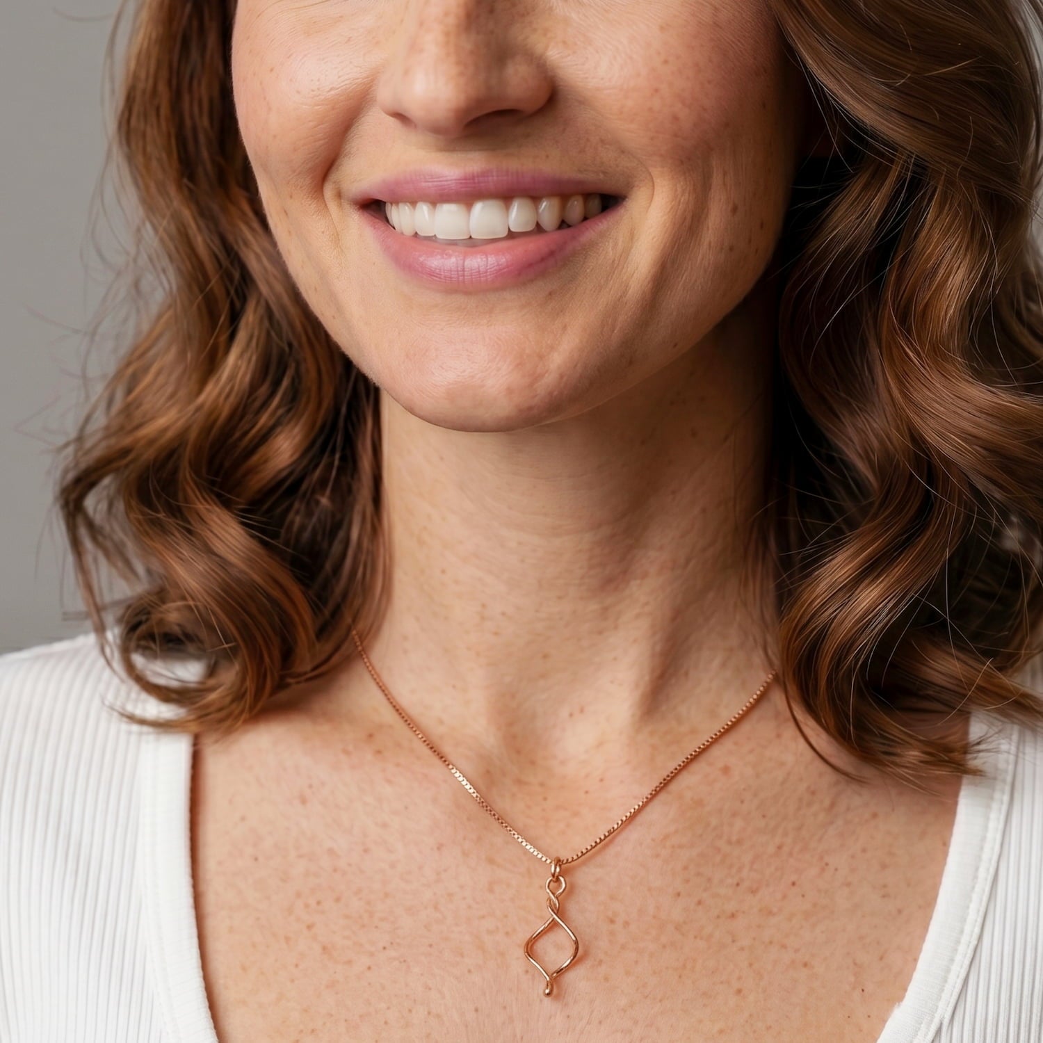 Rose gold vermeil pendant featuring a gently twisted sculptural form suspended from a fine chain, exemplifying minimalist elegance in contemporary sterling silver jewellery.