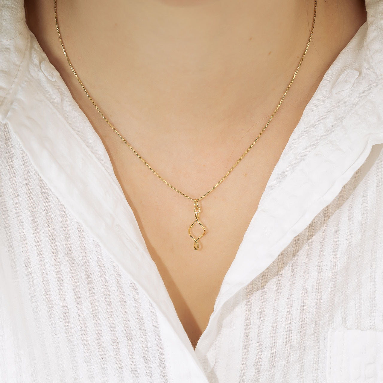 Delicate yellow gold vermeil pendant featuring a simple twisted design suspended from a fine chain, exemplifying contemporary and refined sterling silver jewellery by Azendi.