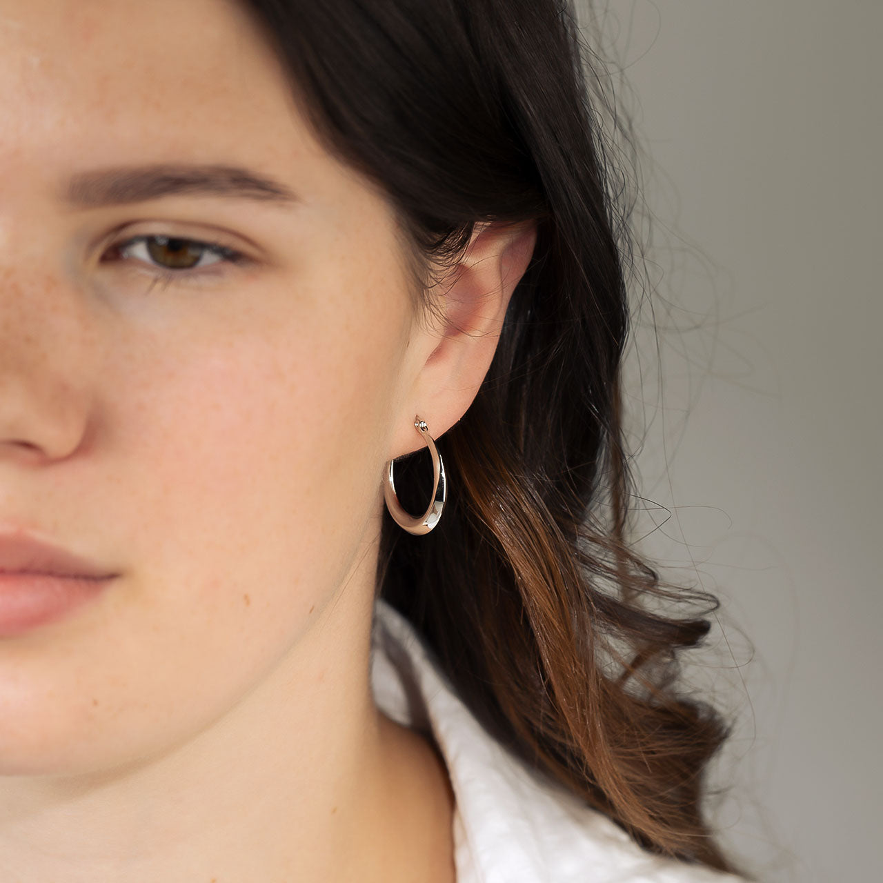 Polished sterling silver large hoop earrings with beveled edges, offering a contemporary and sculptural design that enhances modern silver jewellery collections.