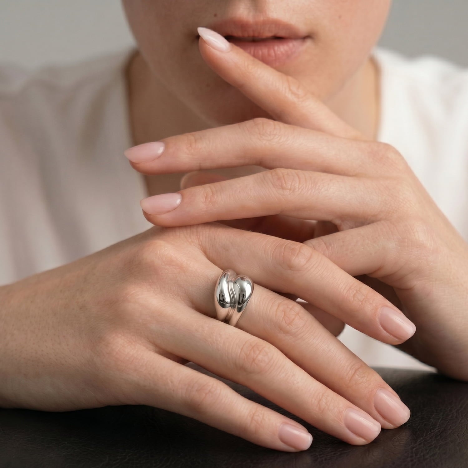 Model wears a polished and sculptural sterling silver ring.