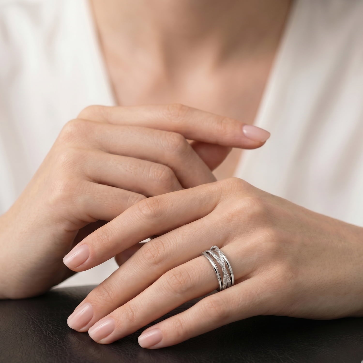 Model wears four stranded polished sterling silver ring. Two strands are set with clear cubic zirconia stones.