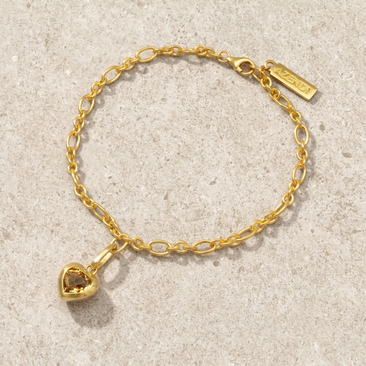 Gold vermeil bracelet with a heart-shaped citrene charm on a light grey background