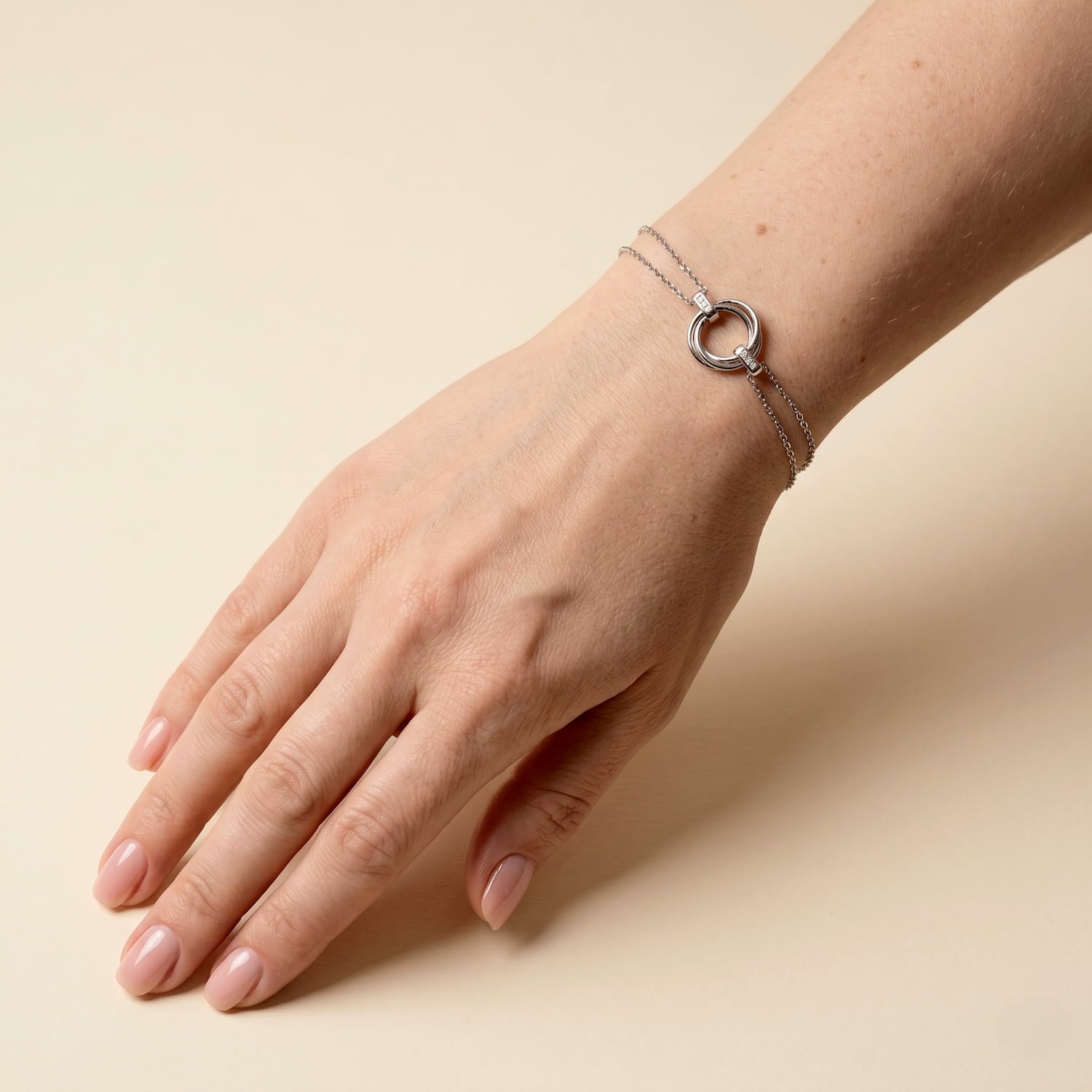 A sterling silver bracelet featuring an intertwined love knot centerpiece accented with lab-grown diamonds, crafted for refined contemporary elegance, modelled on the wrist.
