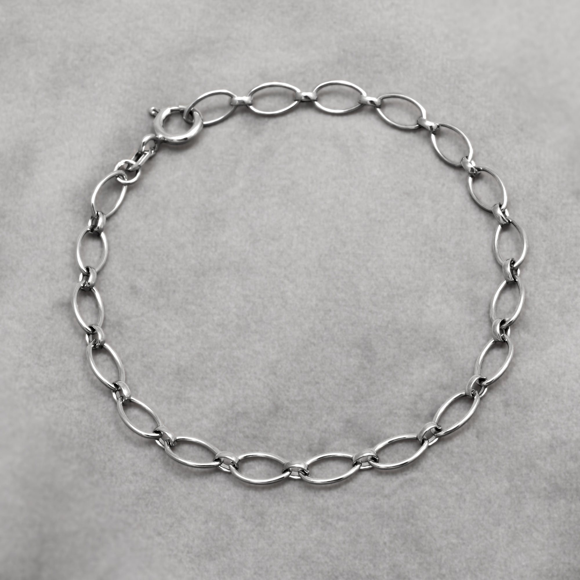 Silver oval links chain bracelet on a grey background