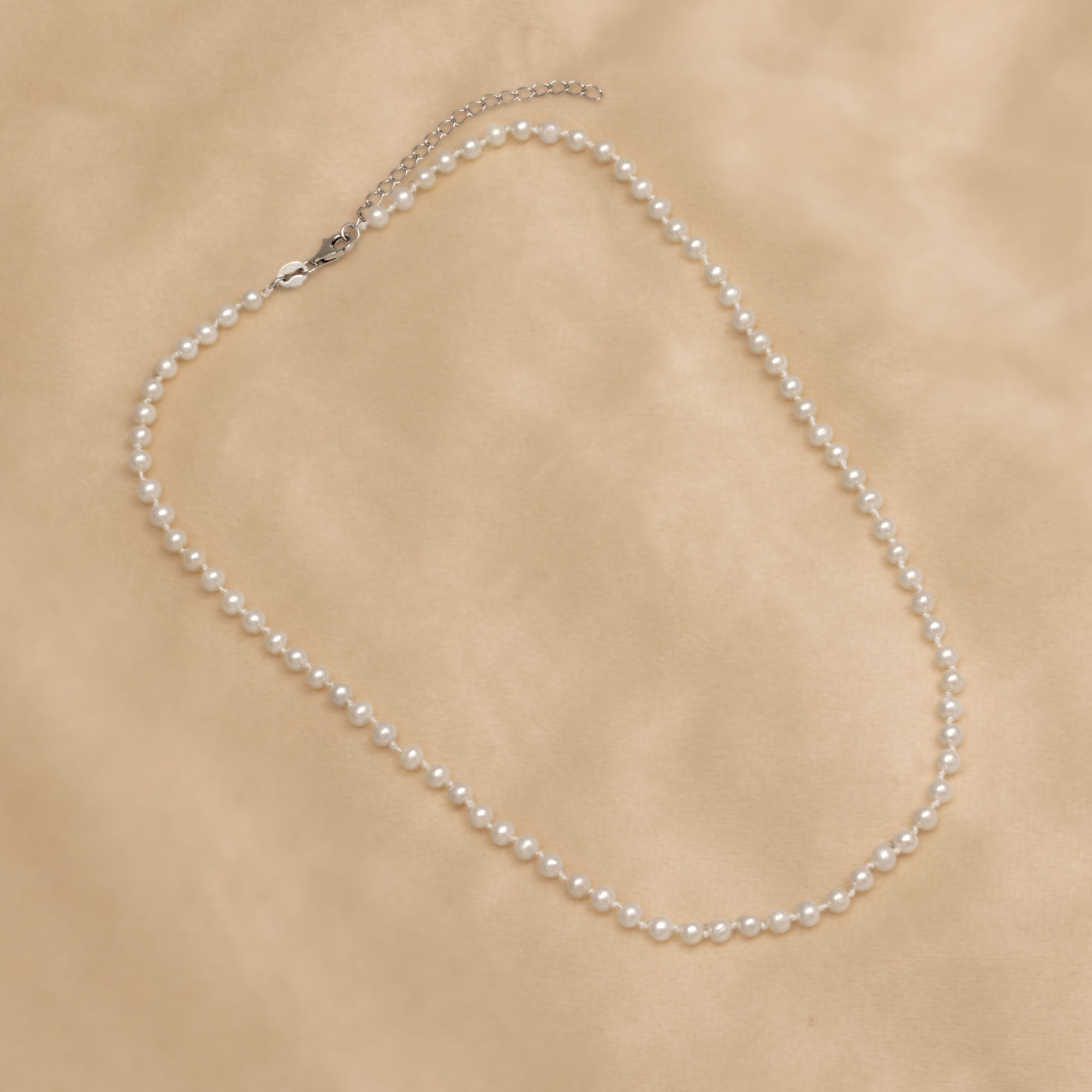 Pearl necklace on a beige background