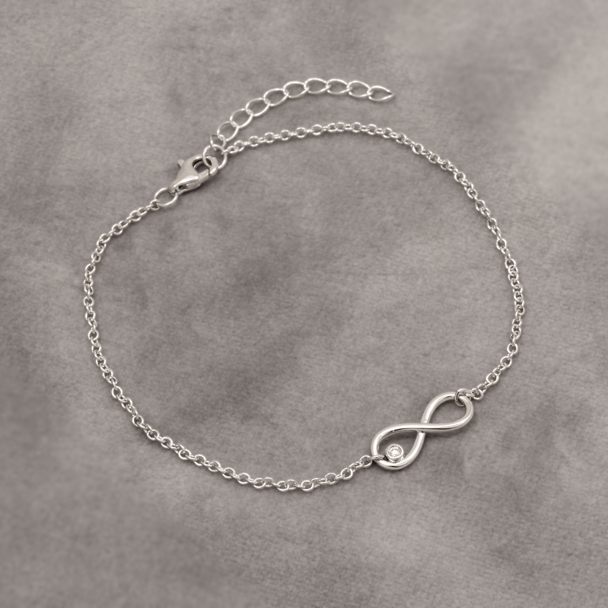 Silver bracelet with an infinity symbol on a gray background