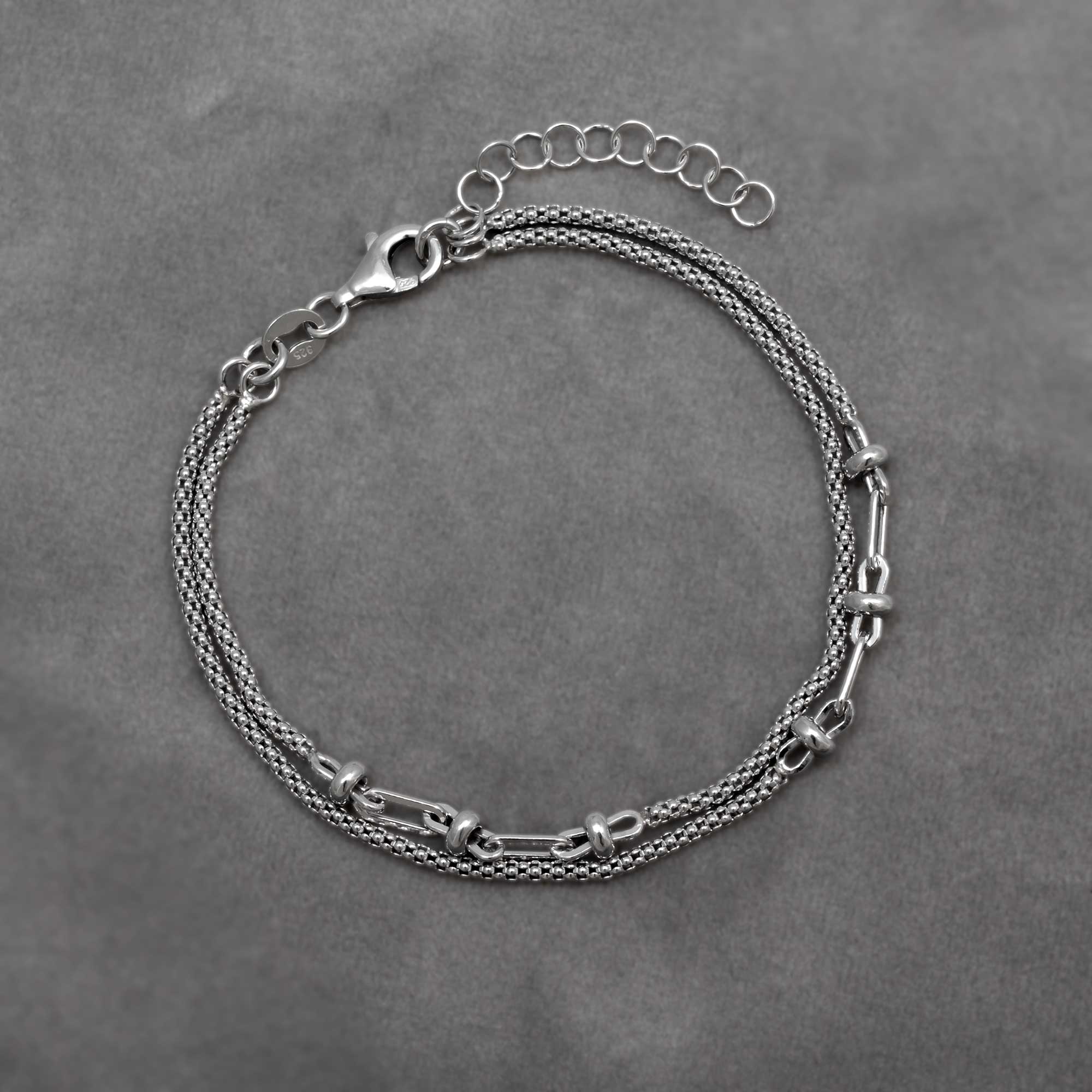 Sterling silver double popcorn chain bracelet with feature links on a grey background