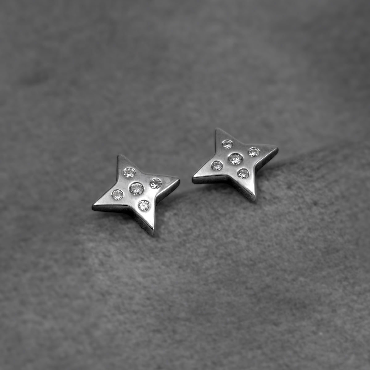 Sterling silver star stud earrings with lab grown diamonds, shown against a soft grey background.