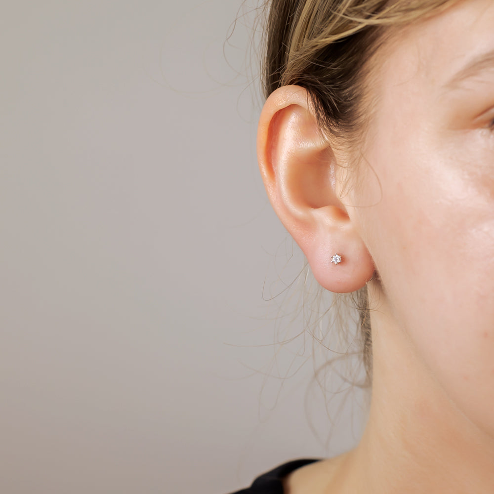Single sterling silver stud earring featuring a small sparkling cubic zirconia stone, worn on the earlobe for a subtle and elegant silver jewellery accent.