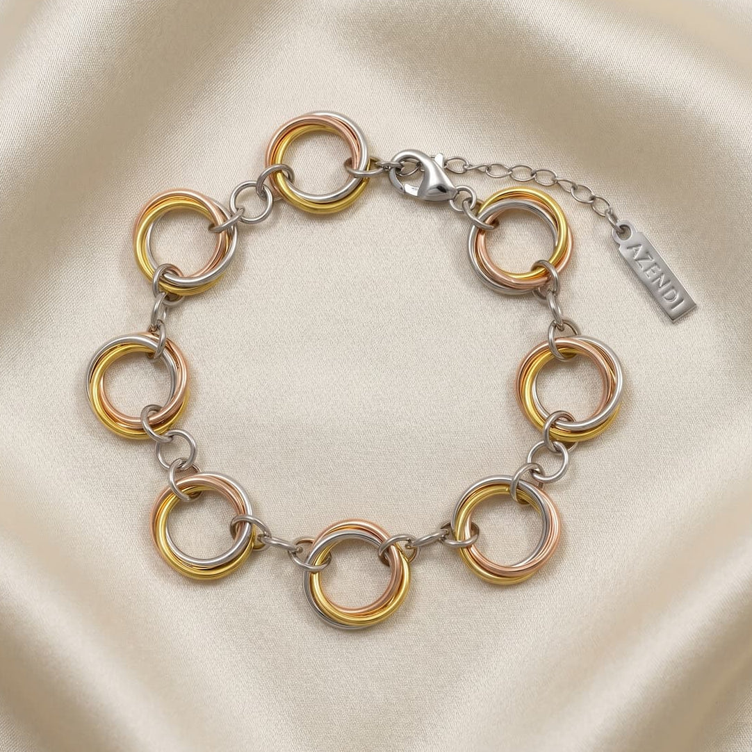 Sterling silver bracelet featuring linked tri-color circular rings with a polished finish and adjustable chain clasp, exemplifying contemporary British silver jewellery design.
