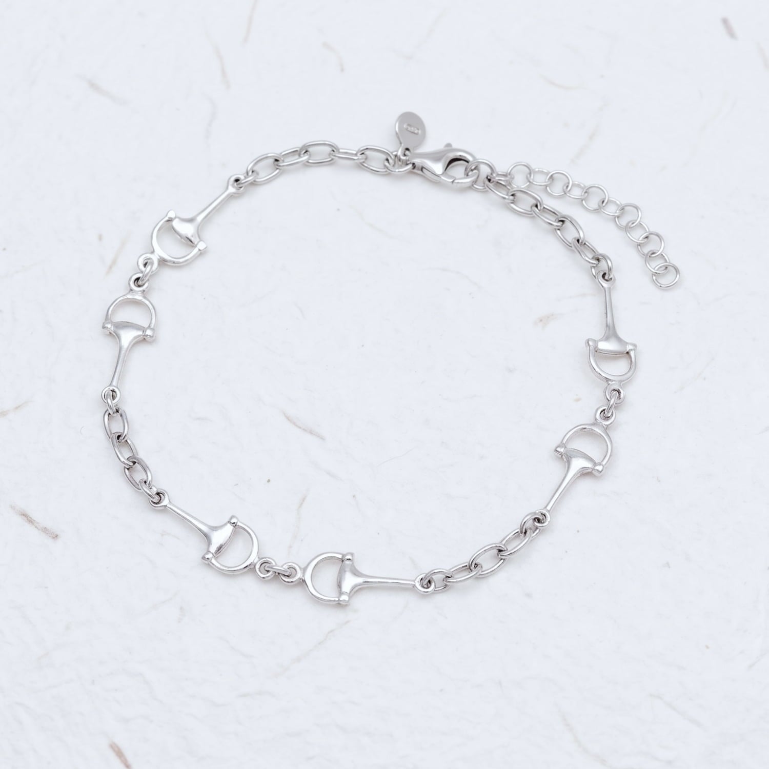 Delicate sterling silver bracelet featuring three snaffle-inspired chain links connected by polished oval links, finished with an adjustable extension for a refined fit.
