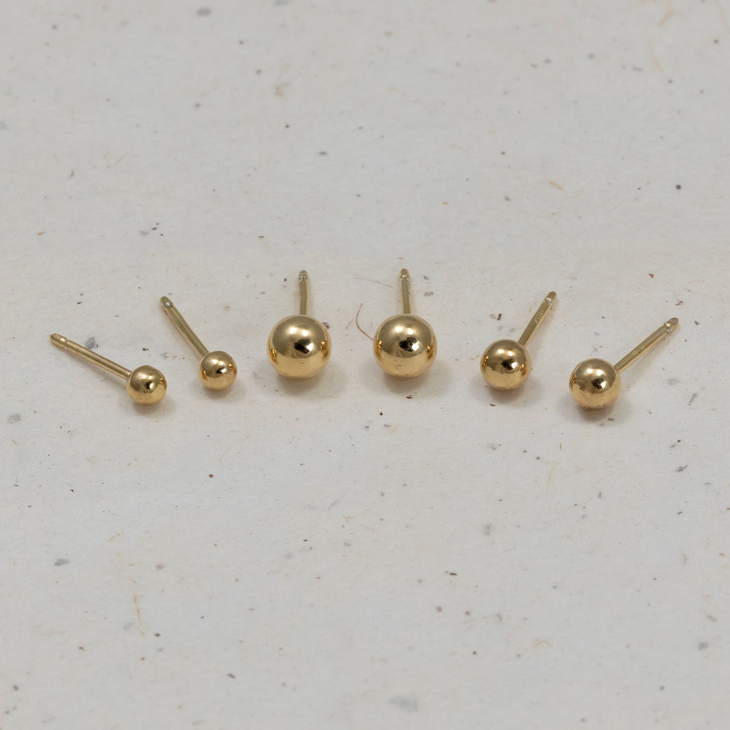 Set of polished gold vermeil ball stud earrings available in three sizes, showcasing sleek minimalist spheres for a versatile and elegant jewellery option.