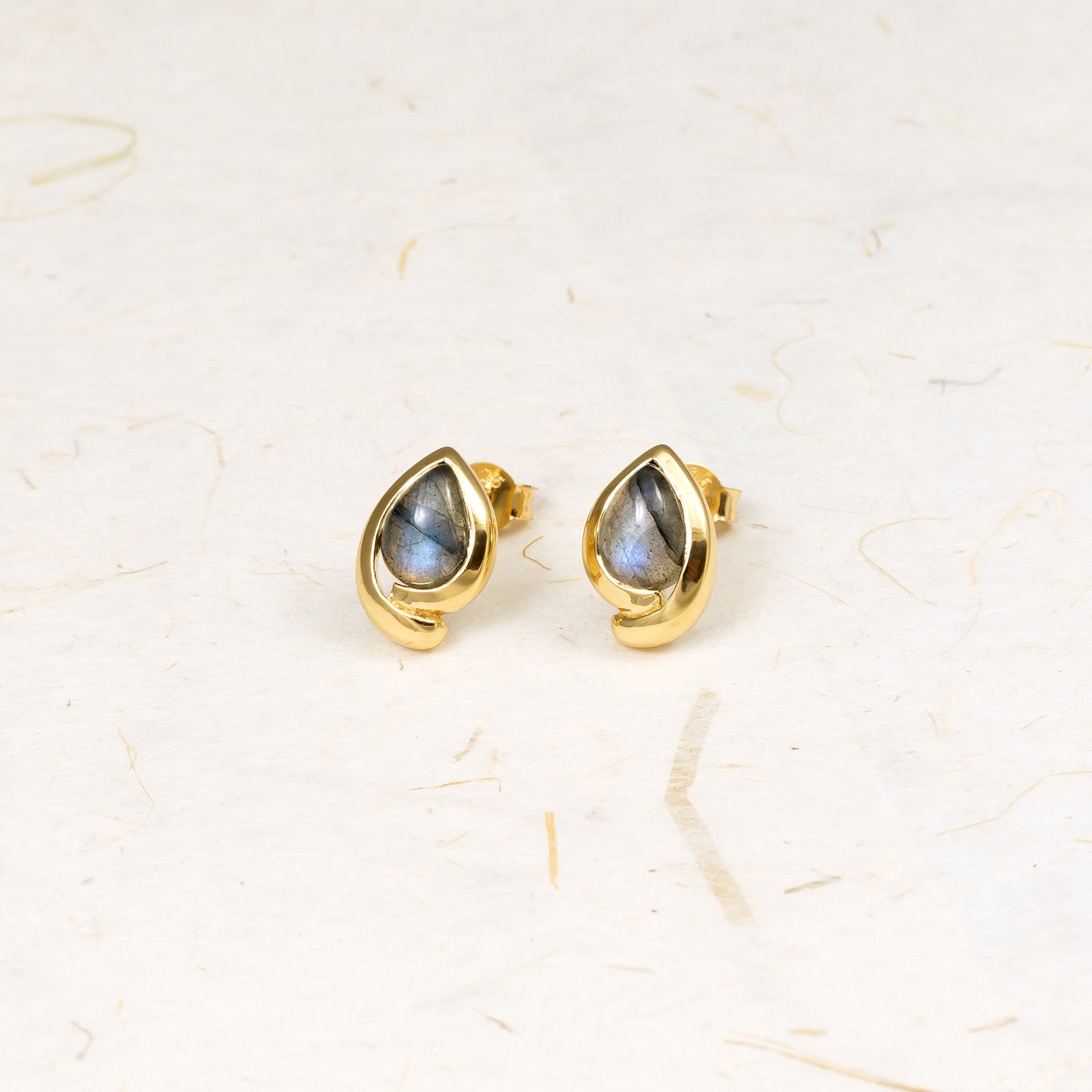 Gold vermeil stud earrings featuring teardrop-shaped spectrolite gemstones framed by a smooth, sculptural bezel setting, exemplifying contemporary sterling silver jewellery design.