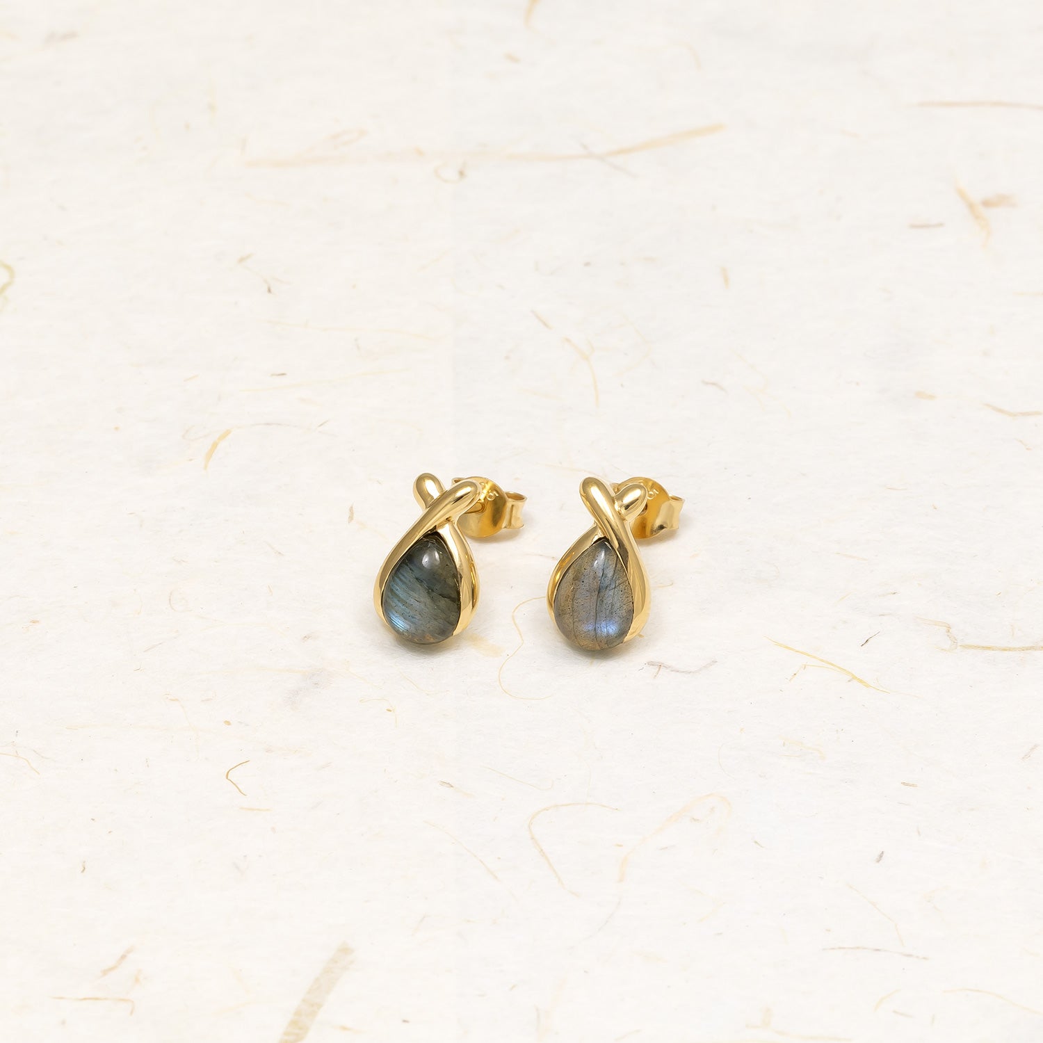 Gold vermeil stud earrings featuring teardrop-shaped spectrolite stones wrapped in a smooth, elegant gold setting, showcasing refined and contemporary design.
