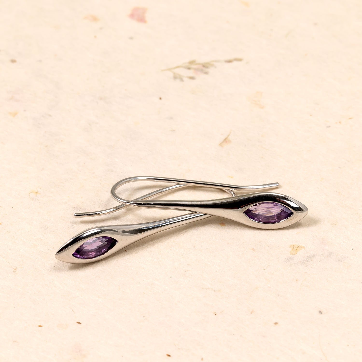 Pair of sterling silver drop earrings with marquise-cut amethyst stones set in sleek, elongated designs, reflecting a contemporary and elegant silver jewellery style.