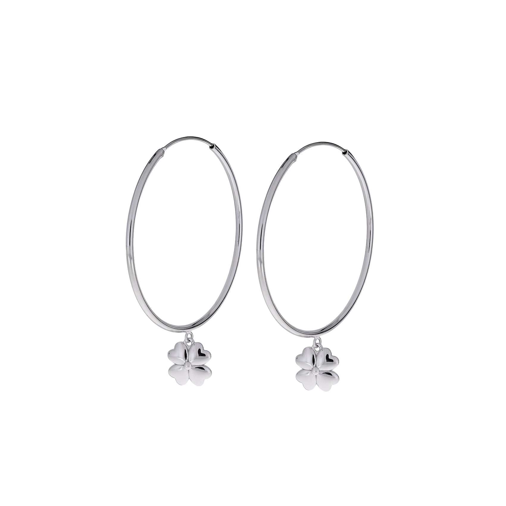 Slim sterling silver hoop earrings featuring sculptural four-leaf clover charms, blending elegant simplicity with contemporary British silver jewellery design.