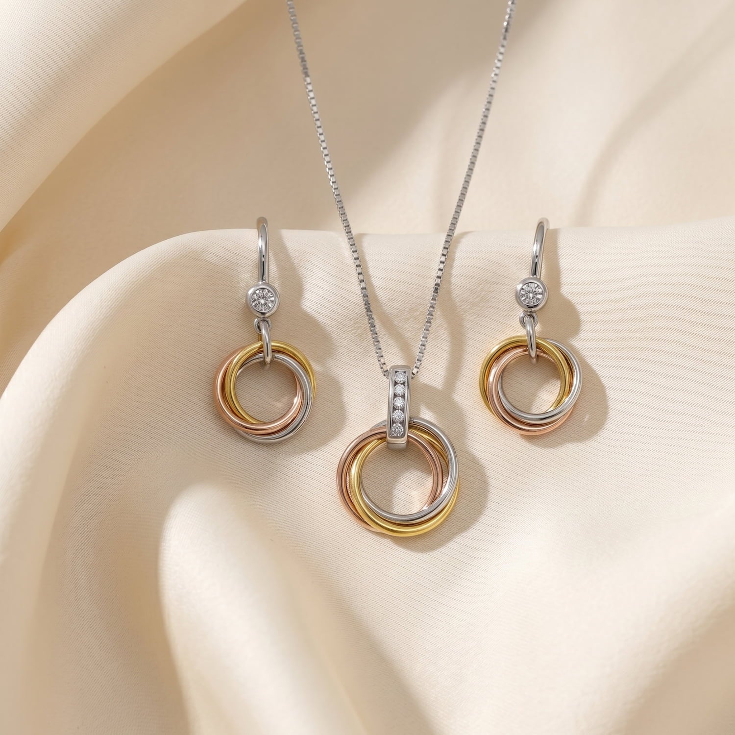 Mixed vermeil pendant and drop earrings with intertwined love knot circles accented by lab-grown diamonds.
