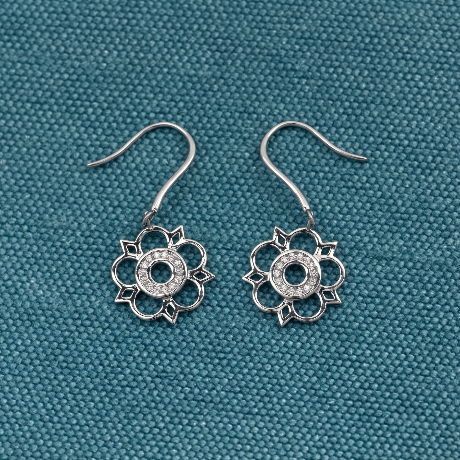 Intricately designed sterling silver drop earrings featuring delicate cut-out Yorkshire rose motifs, showcasing refined sculptural elegance in contemporary silver jewellery.