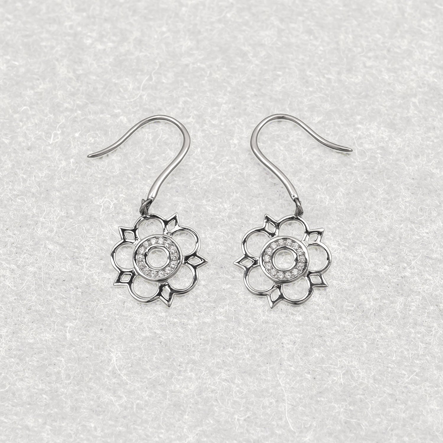 Intricately designed sterling silver drop earrings featuring delicate cut-out Yorkshire rose motifs, showcasing refined sculptural elegance in contemporary silver jewellery.