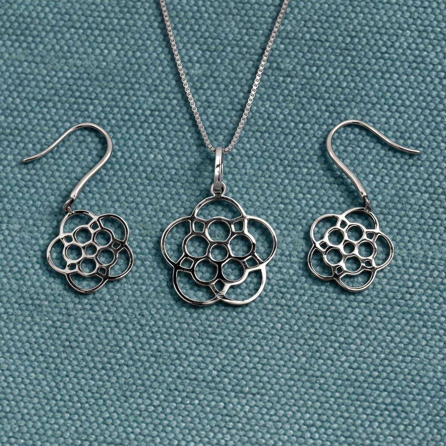 Delicately crafted sterling silver drop earrings featuring a stylised Yorkshire rose design with polished openwork petals, exemplifying elegant sculptural silver jewellery.