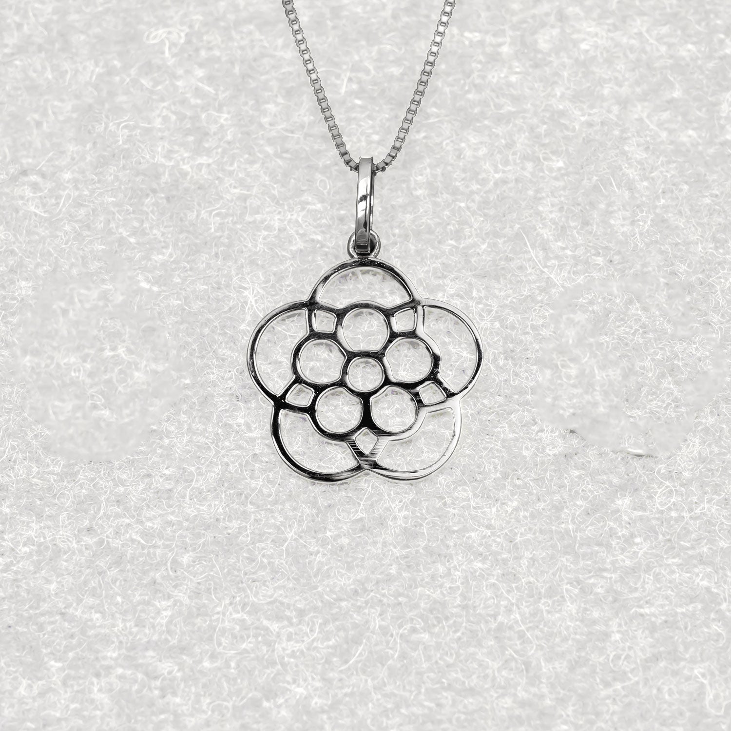Openwork sterling silver pendant inspired by the Yorkshire rose, featuring a sculptural, stylised floral design suspended from a fine chain for elegant everyday wear.
