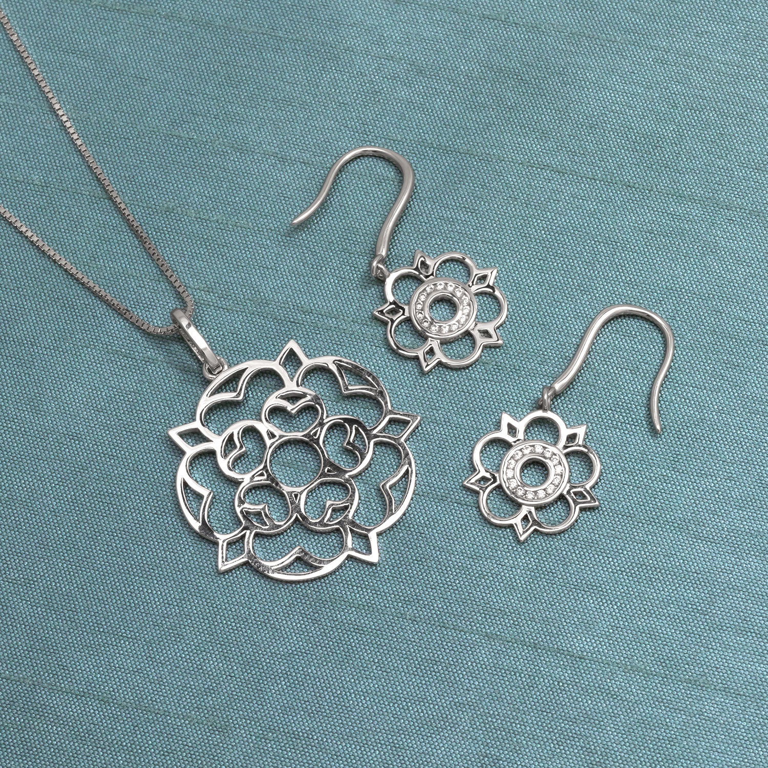 Intricately designed sterling silver pendant and matching earrings set inspired by Yorkshire rose, featuring openwork floral motifs with a refined sculptural finish.