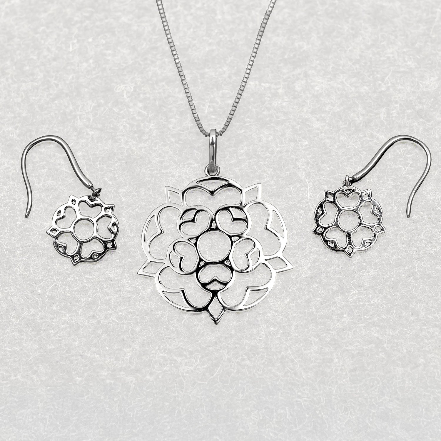 Sterling silver necklace pendant and matching earrings featuring a sculptural Yorkshire rose design with smooth, polished surfaces for elegant contemporary silver jewellery.