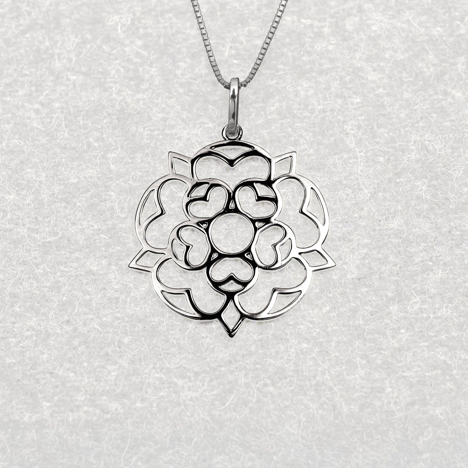 Openwork sterling silver pendant inspired by the traditional Yorkshire rose emblem, featuring a sculptural design with smooth polished surfaces on a fine chain.