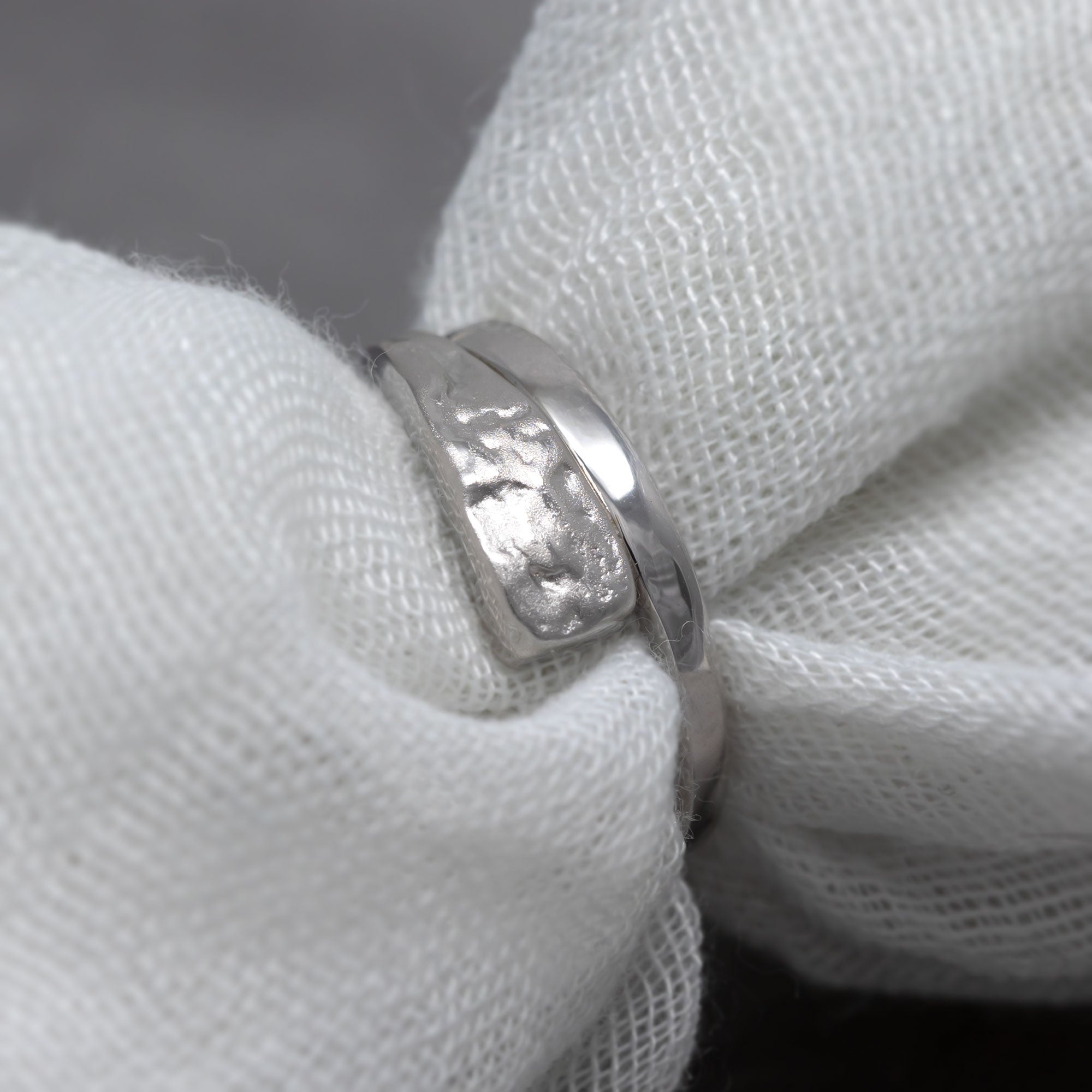 Sterling silver ring featuring a combination of smooth polished and textured hammered surfaces, showcasing a contemporary and sculptural design in fine silver jewellery.