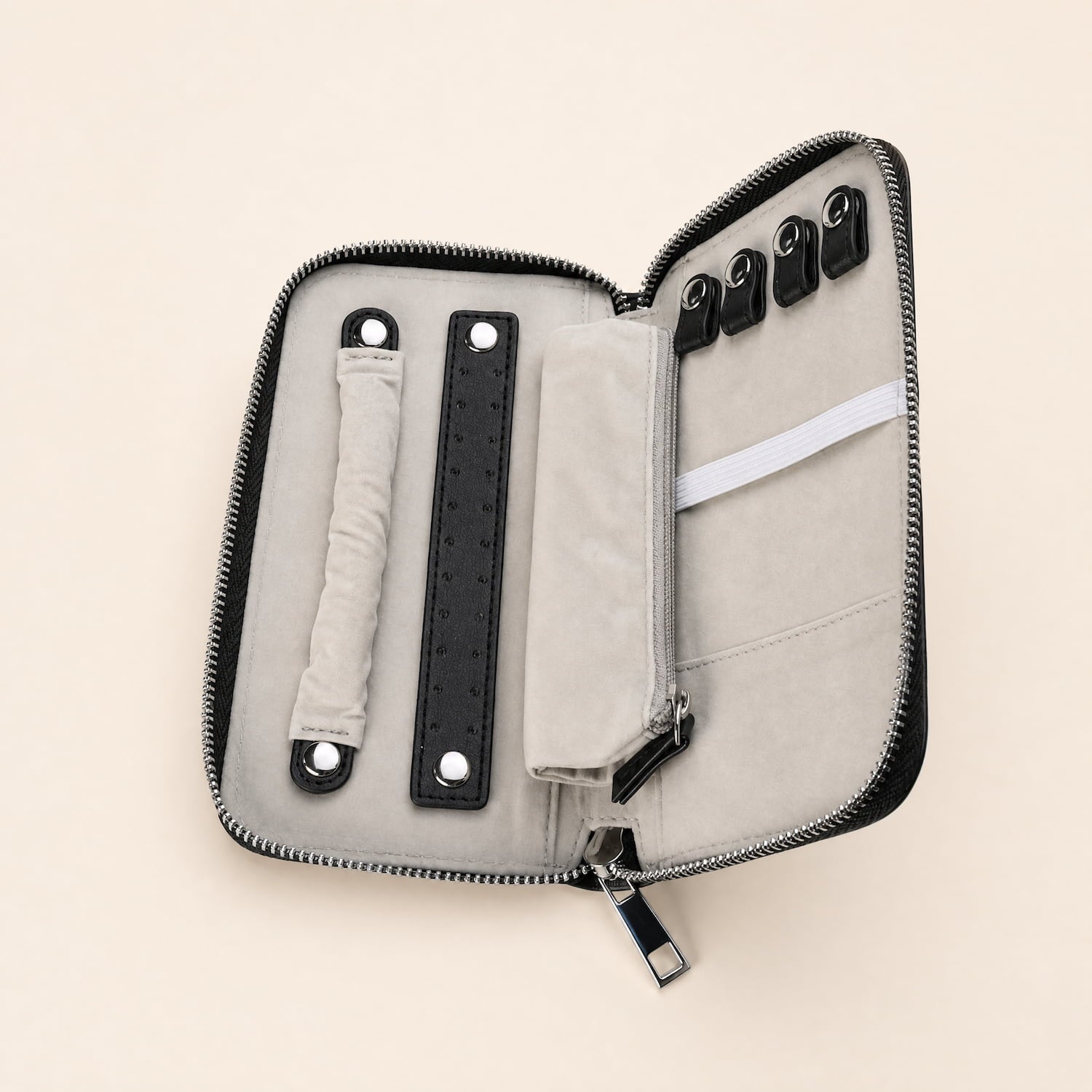 Open jewellery travel wallet in soft grey velvet and PU leather with multiple compartments and secure zipper closure, designed to protect and organise pieces while travelling.