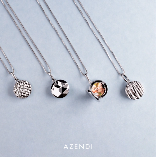 Collection of sterling silver satin finish locket pendants with varied textured surfaces, one open to reveal a small photo, each suspended on an adjustable chain.