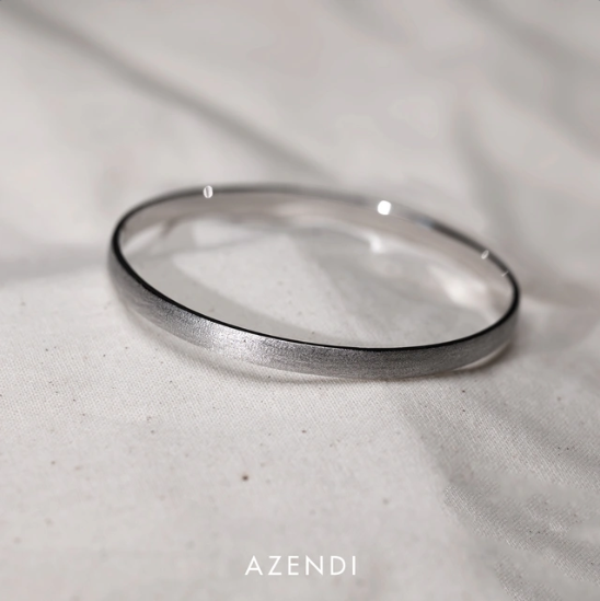 Sterling silver bangle with a smooth satin finish, showcasing a sleek and modern design that highlights expert craftsmanship and timeless elegance.