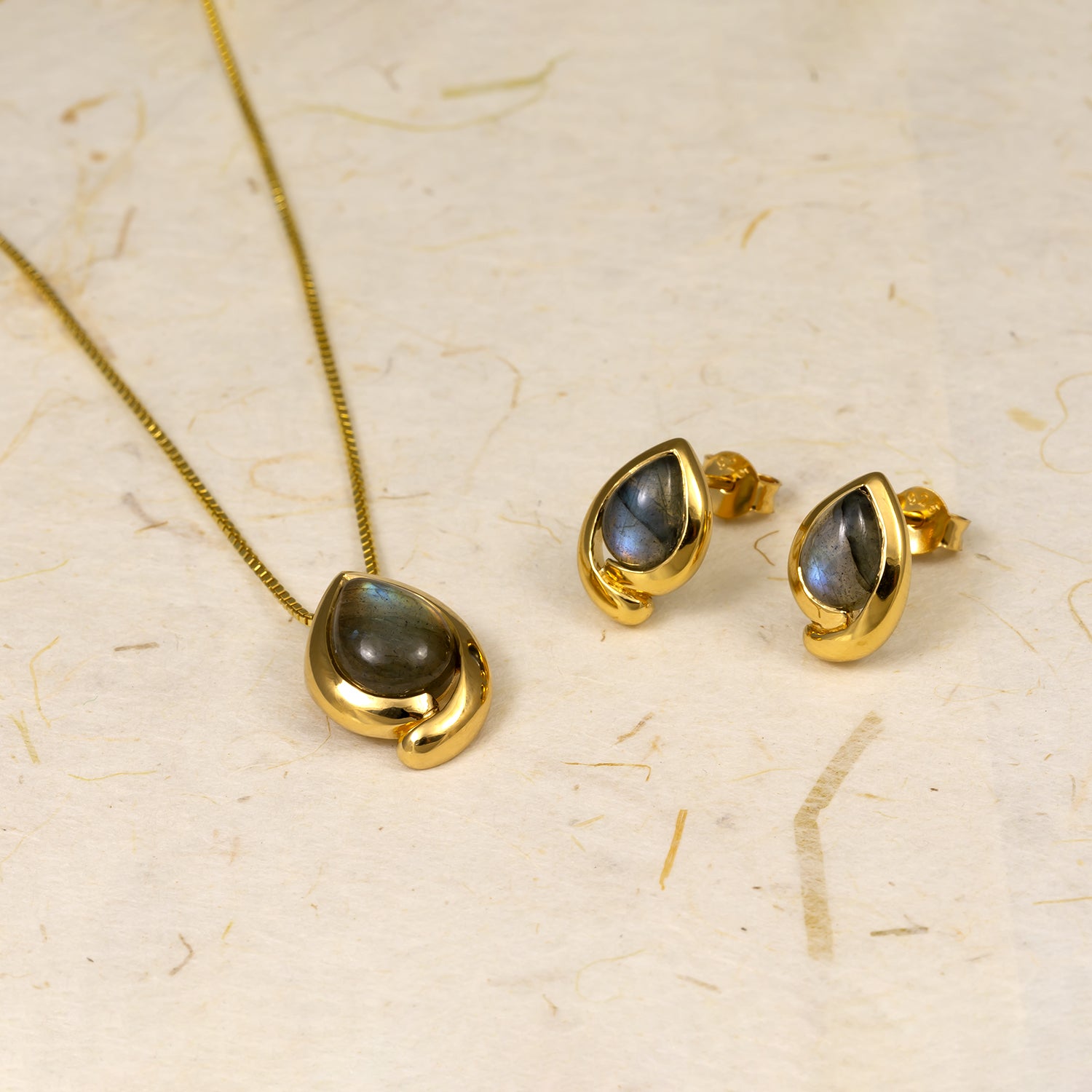 Gold vermeil teardrop necklace and matching stud earrings featuring polished spectrolite gemstones, showcasing a sculptural and contemporary design in fine jewellery.