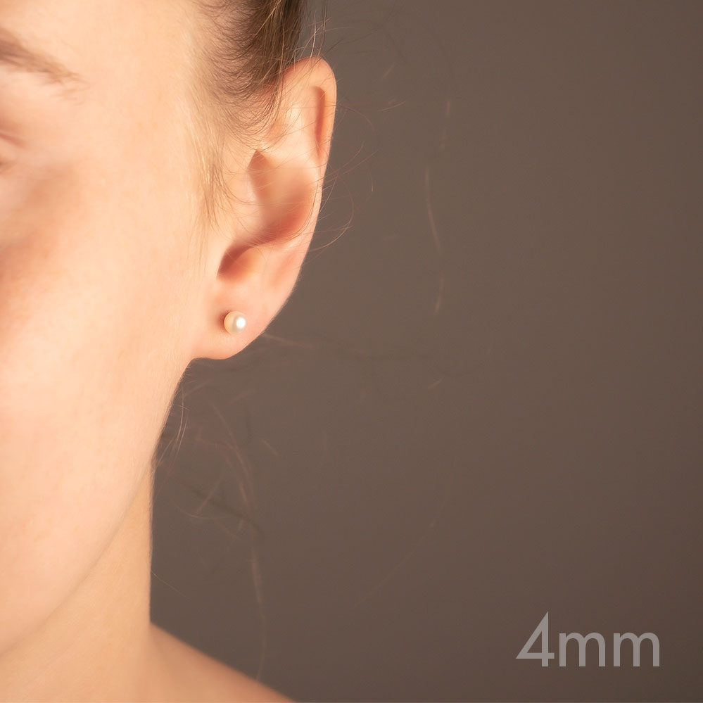 Close-up of an ear wearing a delicate white pearl stud earring set in sterling silver, highlighting a timeless and elegant design in fine silver jewellery.