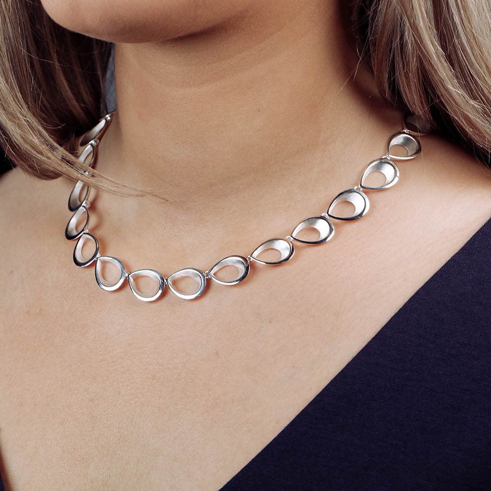 Sterling silver necklace featuring linked teardrop-shaped loops with a smooth, polished finish, creating a sculptural and contemporary statement piece.