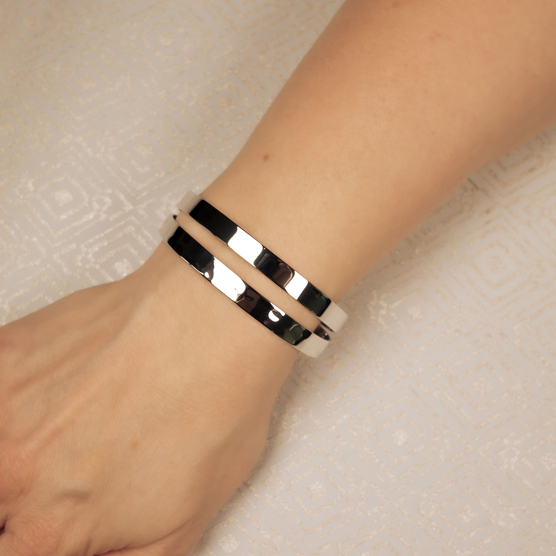 Sleek sterling silver cuff bangle with a hammered and polished finish, featuring an open, double-band design that reflects contemporary British sterling silver jewellery style.
