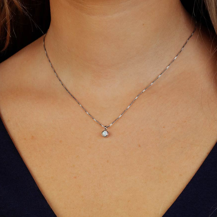 Delicate sterling silver pendant featuring a small opal birthstone, suspended on a fine chain for an elegant, understated British-crafted silver jewellery piece.