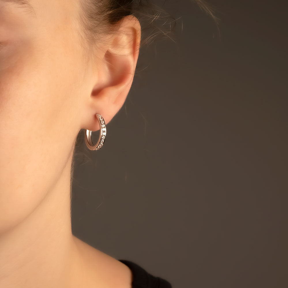 Medium-sized sterling silver hoop earrings featuring a hinged design set with sparkling gemstones, combining subtle luxury and expert British craftsmanship by Azendi.