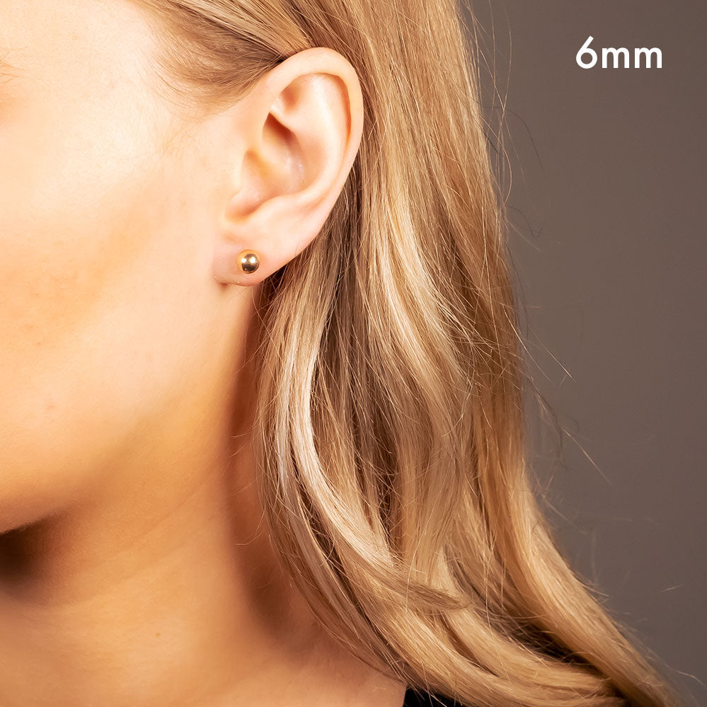 Single rose gold vermeil spherical stud earring worn on the earlobe, showcasing a minimalist and contemporary design from a British sterling silver jewellery brand.