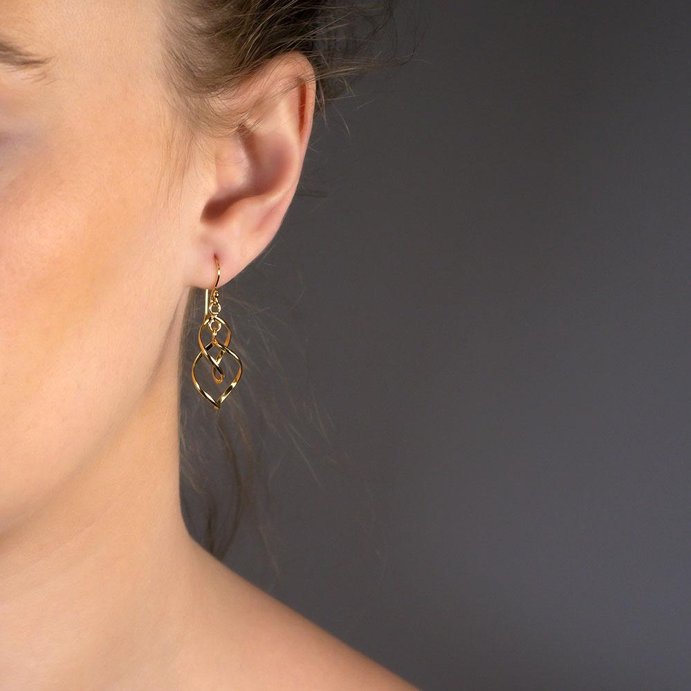 Yellow gold vermeil drop earrings featuring delicate intertwined spiral wave shapes, suspended from a fine hook for a sculptural and elegant designer jewellery look.
