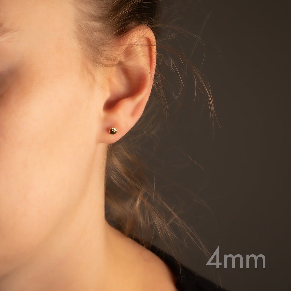 Yellow gold vermeil double curved button stud earring with a smooth, sculptural finish, worn on the earlobe for a timeless and elegant look in sterling silver jewellery.